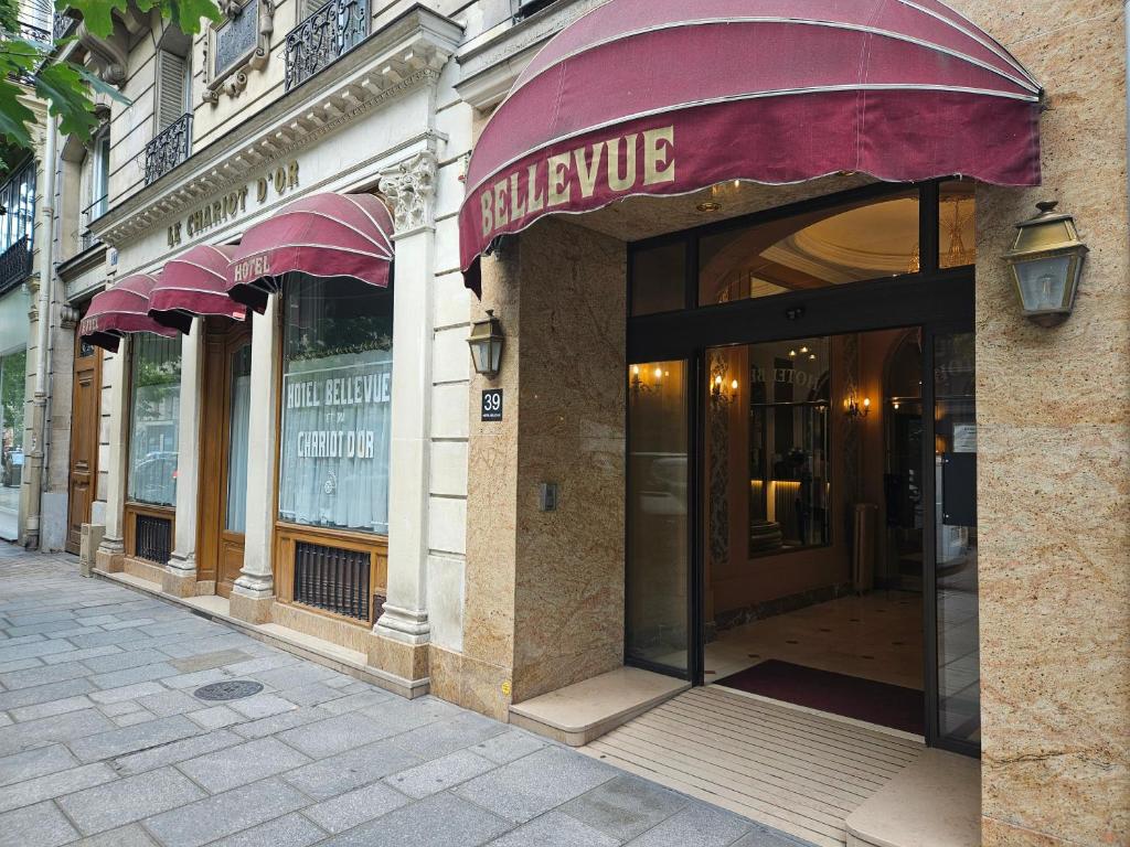 un bâtiment avec un auvent violet dans une rue dans l'établissement Hôtel Bellevue et du Chariot d'Or, à Paris