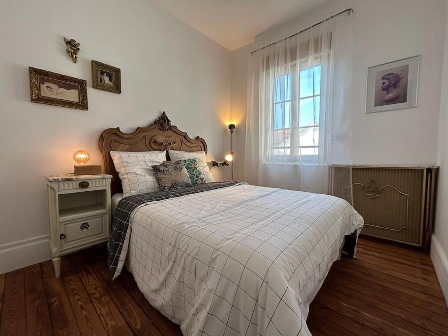 ein Schlafzimmer mit einem großen Bett und einem Fenster in der Unterkunft Chez La Vieille Dame in Cosne Cours sur Loire