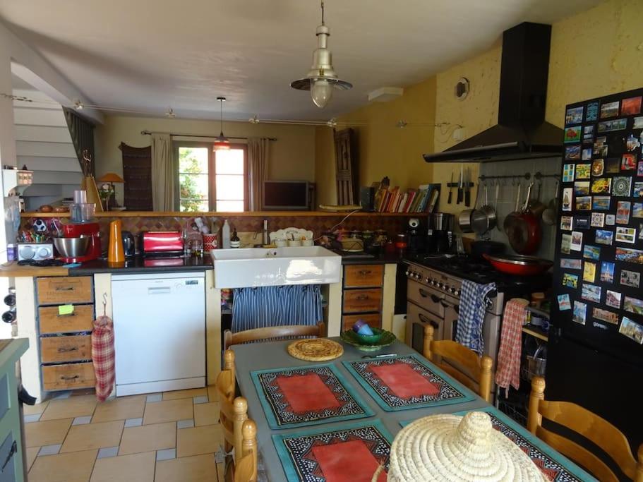 eine Küche mit einem Tisch und einem Herd Top-Backofen in der Unterkunft Maison de bord de mer - vue mer - location à la semaine in Paimpol