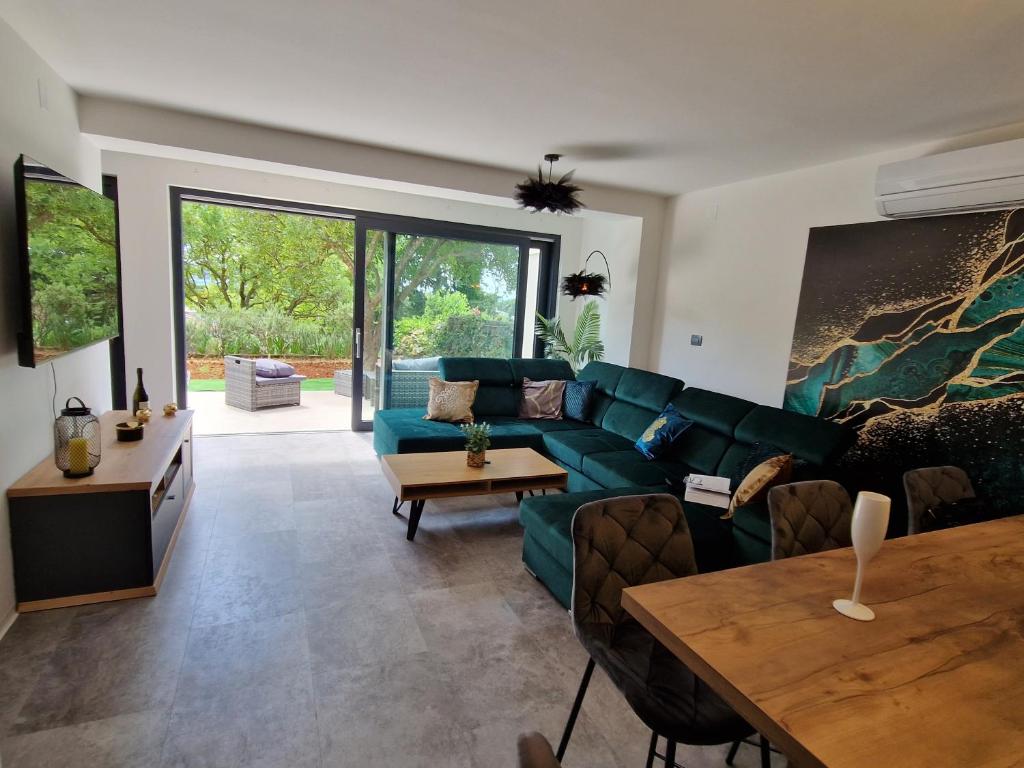 a living room with a green couch and a table at Villa Porta Krk in Krk