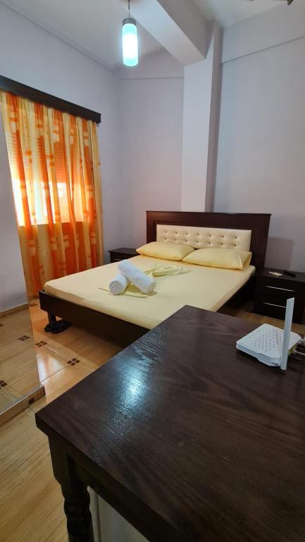 1 dormitorio con 2 camas y mesa con ordenador portátil en Hotel Brace, en Gjirokastra