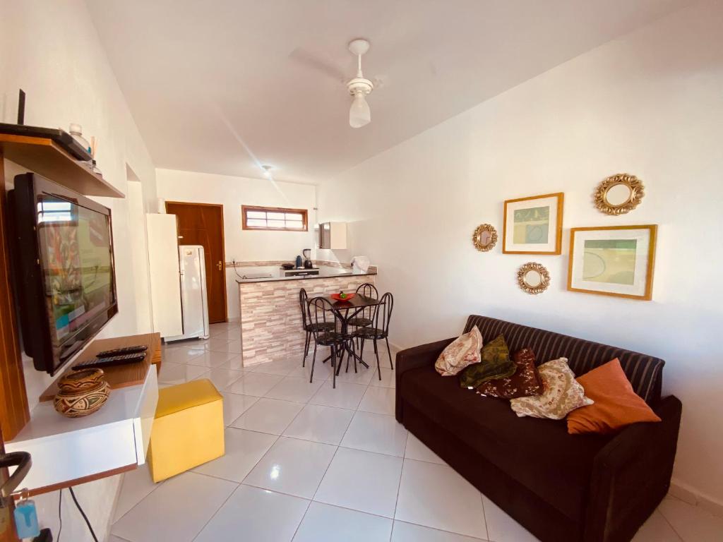 a living room with a couch and a kitchen at Casas Aconchegantes Temporada in Cabo Frio