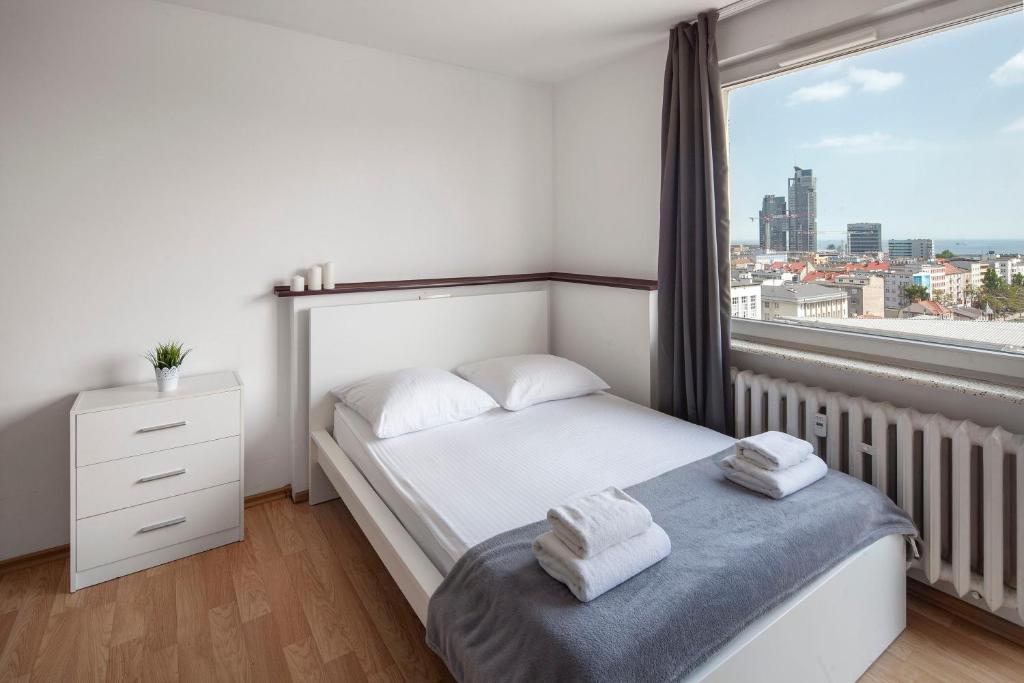 a bedroom with a bed and a large window at Sleepy3city with Sea View II in Gdynia