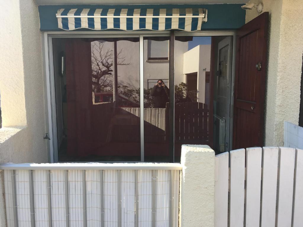 uma porta da frente de uma casa com um toldo listrado em T2 rez de jardin centre station em Fleury