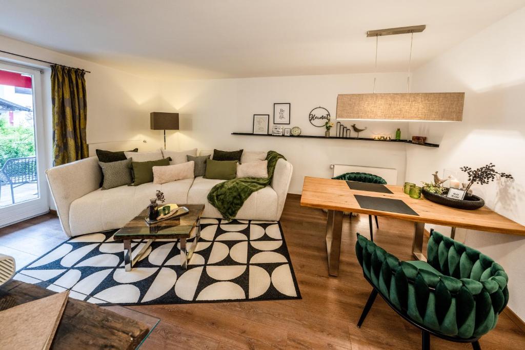 ein Wohnzimmer mit einem Sofa und einem Tisch in der Unterkunft Bayern Resort - Suites & Apartments in Grainau