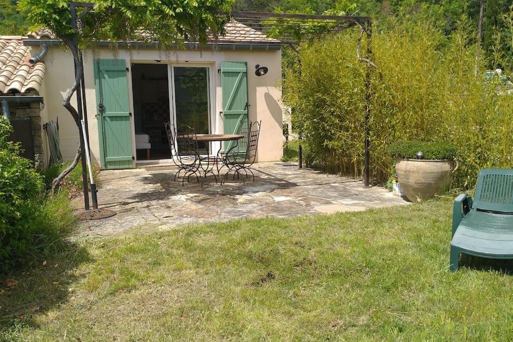 un patio avec une table et des chaises dans une cour dans l'établissement Gîte La Vigne 2 pers - uniquement samedi au samedi, à Saint-Privat