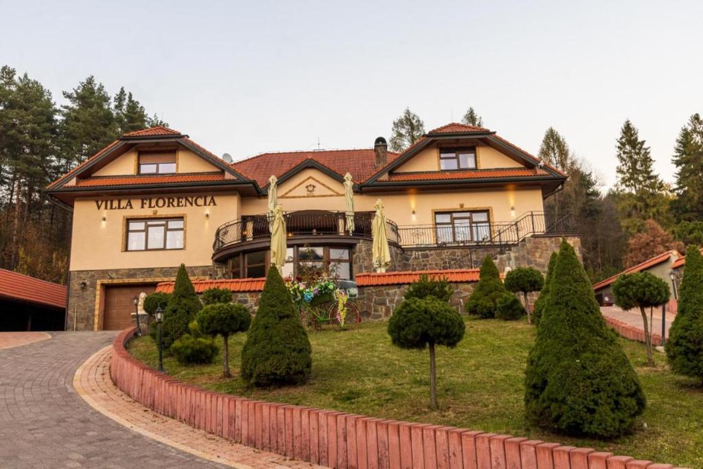 a large house with a garden in front of it at Villa Florencia in Bardejov