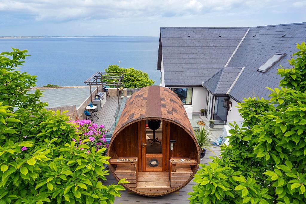 ein Holzboot auf dem Dach eines Hauses in der Unterkunft NEWCASTLE stunning sea views & forest backdrop in Newcastle