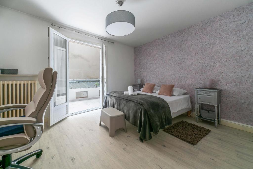 sypialnia z łóżkiem, oknem i krzesłem w obiekcie Le Dejoux - Appartement avec terrasse en centre ville w mieście Vichy