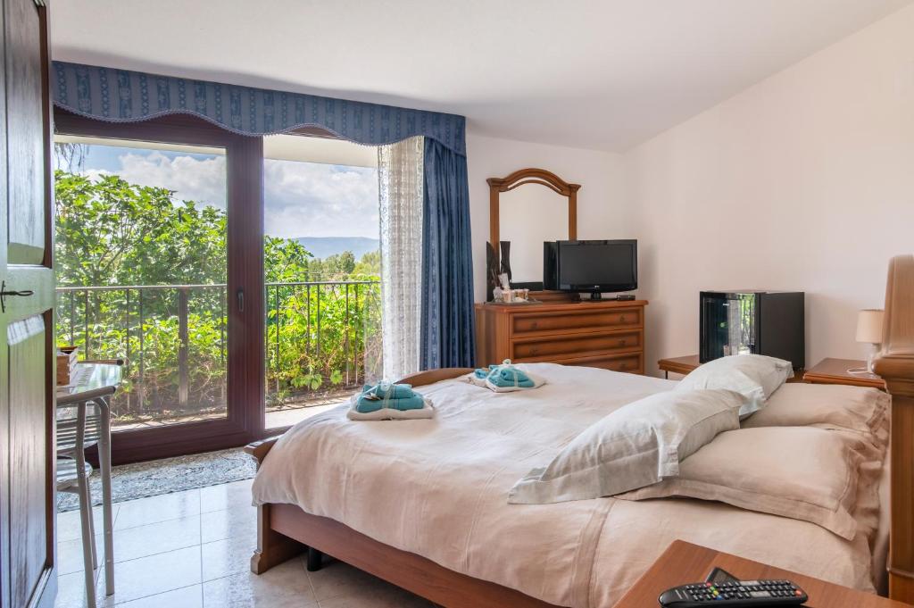 sypialnia z dużym łóżkiem i dużym oknem w obiekcie Le Calle w mieście Iglesias