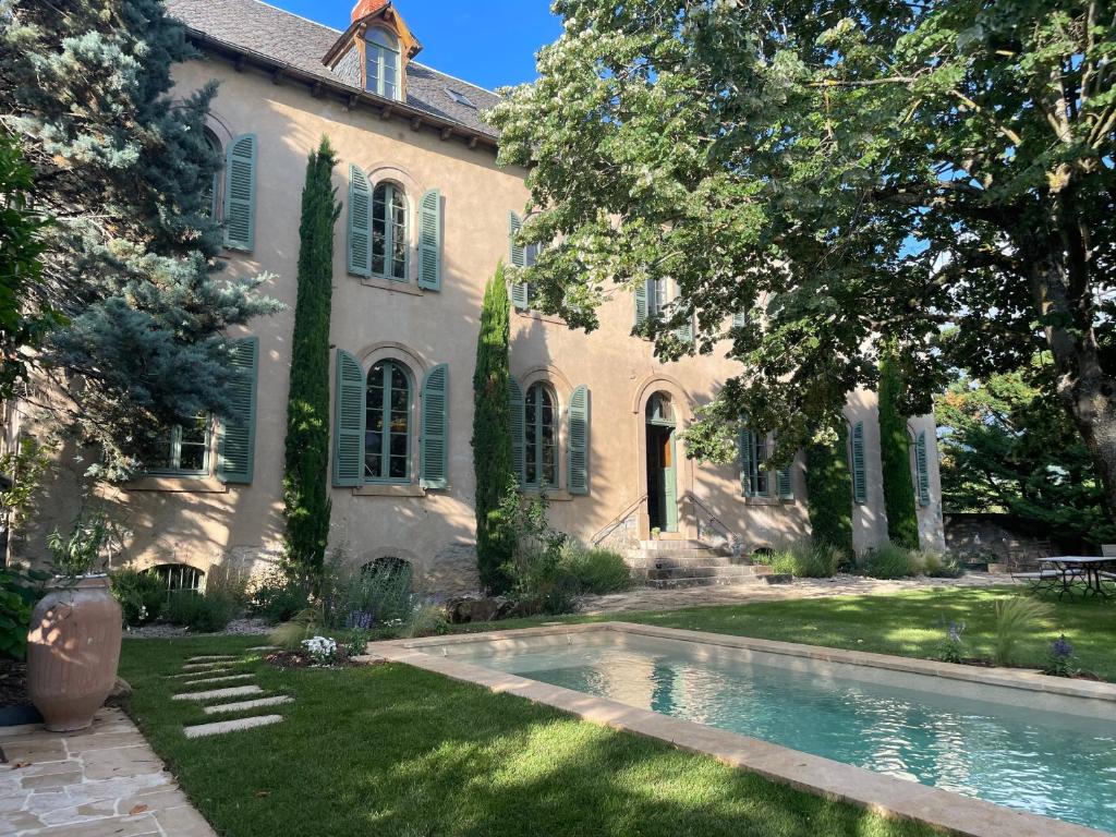 a house with a swimming pool in front of it at Couvent de la Salette & Spa in Millau