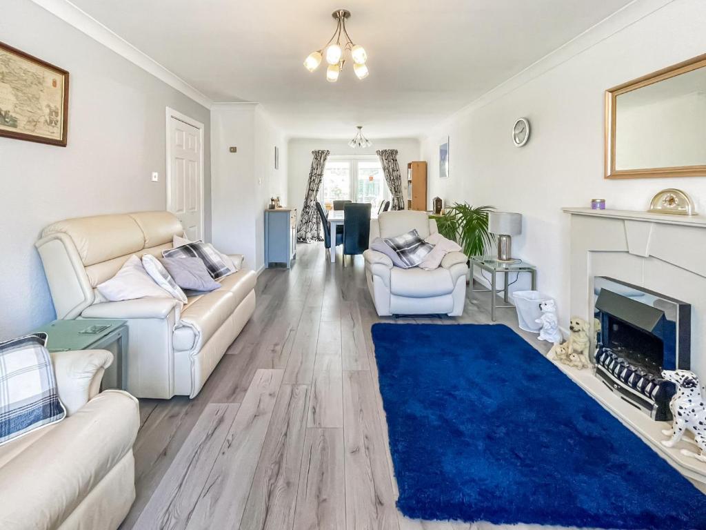 a living room with white furniture and a blue rug at Buxton Holiday Home in Buxton