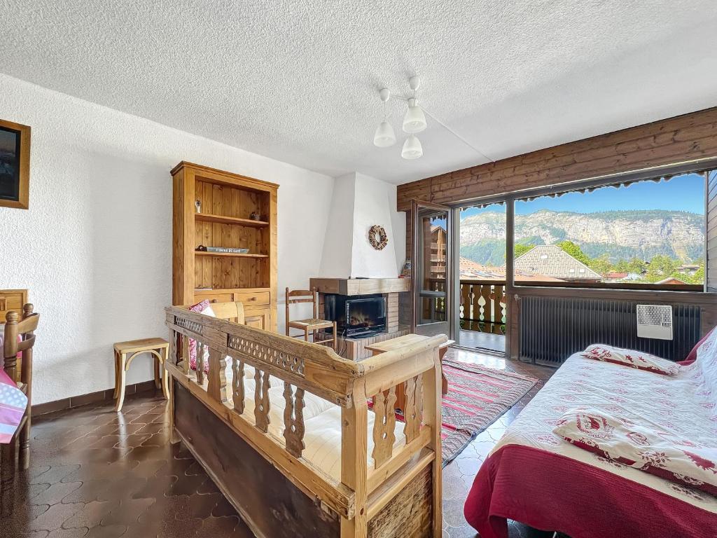 une chambre avec un lit et un bureau et un balcon dans l'établissement GR007 - 2 Pièces 5/6 pers centre Carroz, aux Carroz d'Arâches