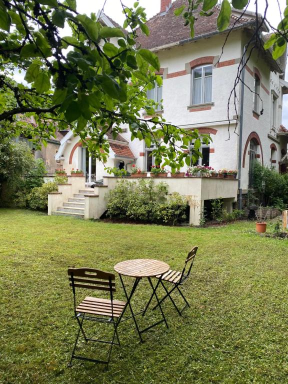 2 Stühle und ein Tisch vor einem Haus in der Unterkunft La Maison du Markstein in Linthal