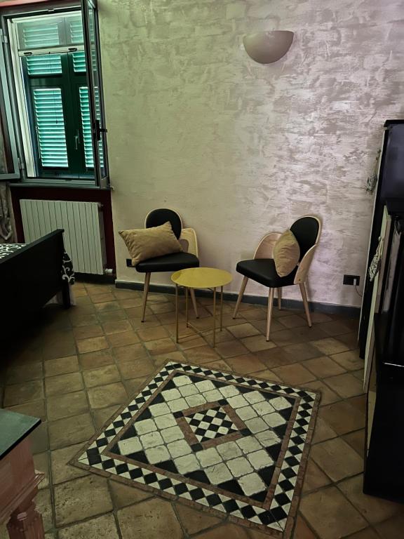 a room with chairs and a table and a rug at Casa Marieta in Sarzana