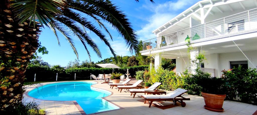 a swimming pool with lounge chairs and a house at B&B White House in Peschici