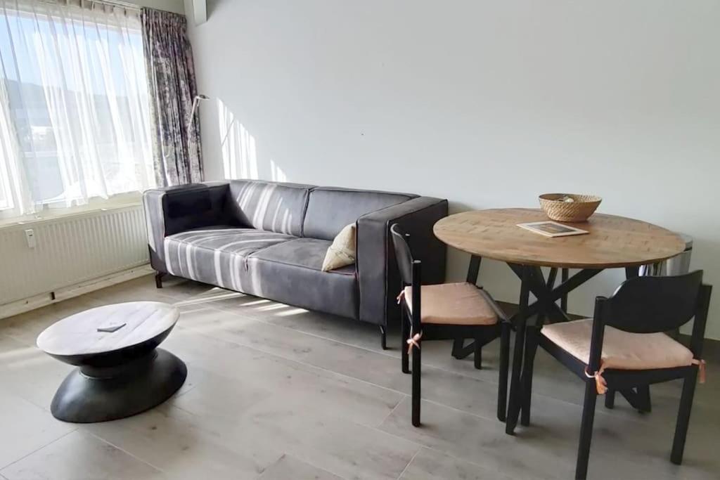 sala de estar con sofá y mesa en Beach Appartement 17 - Callantsoog, en Callantsoog