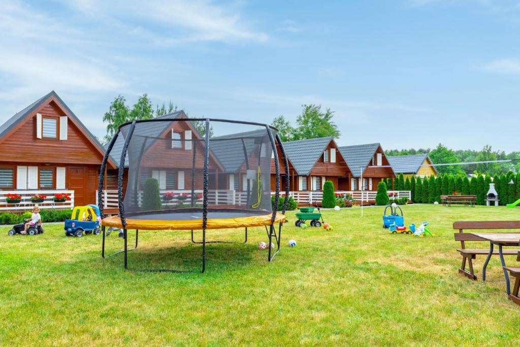 a playground with a trampoline in a yard at Domki Relax in Ustka