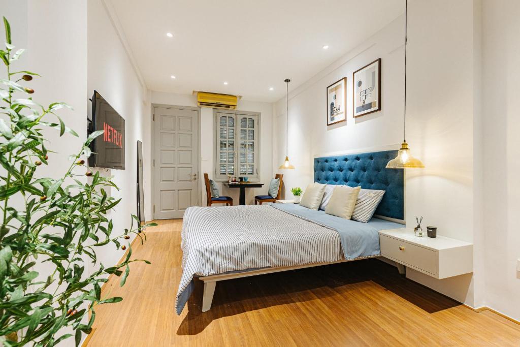 a bedroom with a bed with a blue headboard and a table at VietHOME Trang Tien in Hanoi