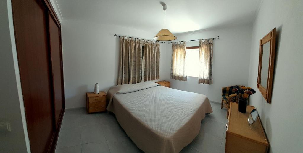 a small bedroom with a bed and a window at Apartamento Oliveira in Vila Real de Santo António