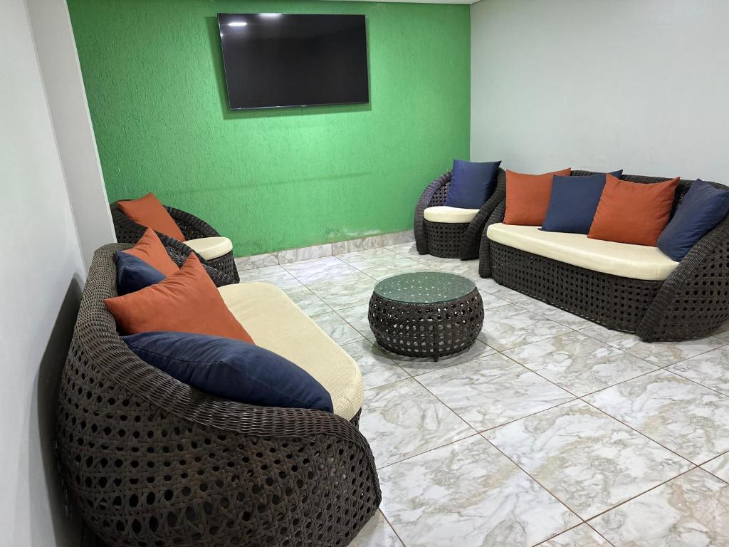 a living room with two couches and a tv at Hotel Planaltina in Planaltina