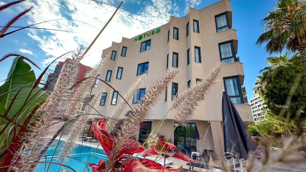 a building with a pool in front of it at Notus Suites in Antalya