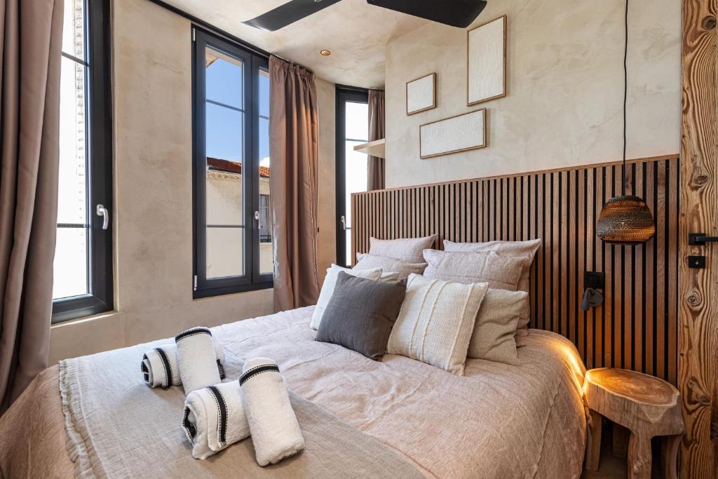 une chambre avec un grand lit avec des oreillers dessus dans l'établissement WABISABI SUITES - BRAILLE, à Cannes