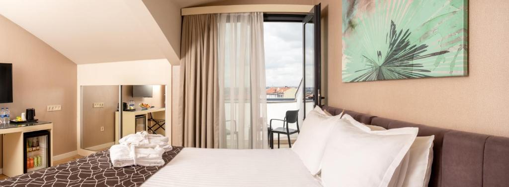 a hotel room with a bed and a large window at Elm Suite Hotel in Istanbul