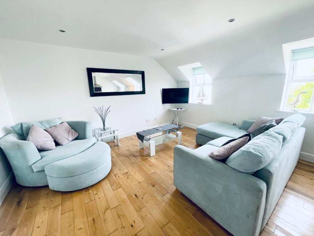 a living room with two couches and a tv at Ballina Town Centre Duplex Apartment in Ballina