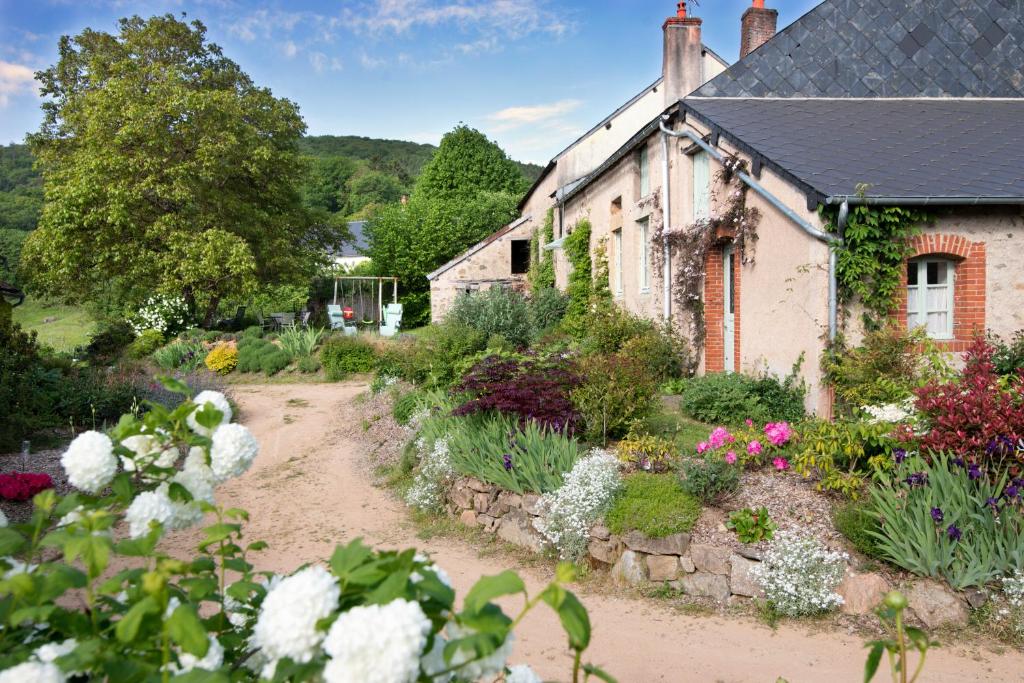 un jardín frente a una casa con flores en Maison de vacances Les Mésanges, à Ménessaire, en Ménessaire