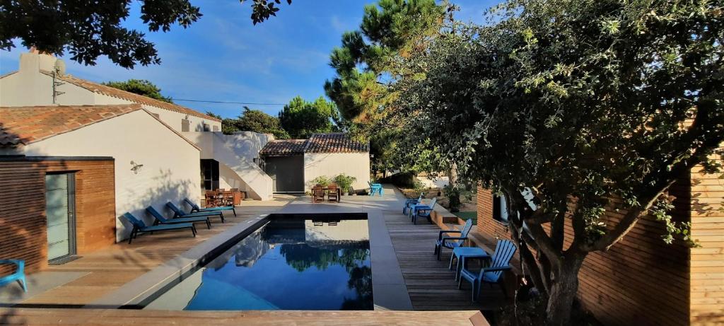 - une piscine avec des chaises bleues à côté d'une maison dans l'établissement Sea-Snow Guest Houses, à Talmont-Saint-Hilaire