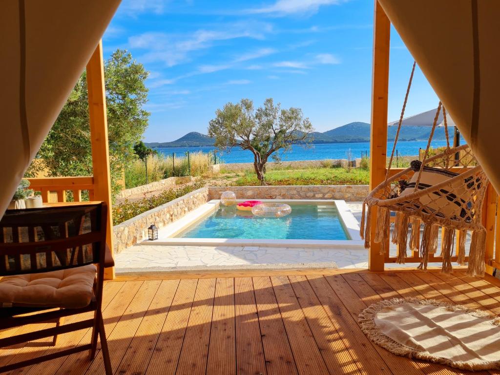 a pool on a deck with a view of the water at AURAS - Glamping Eco Resort in Biograd na Moru