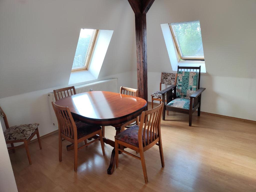 a dining room with a wooden table and chairs at Ferienwohnung neben HBF in Gera