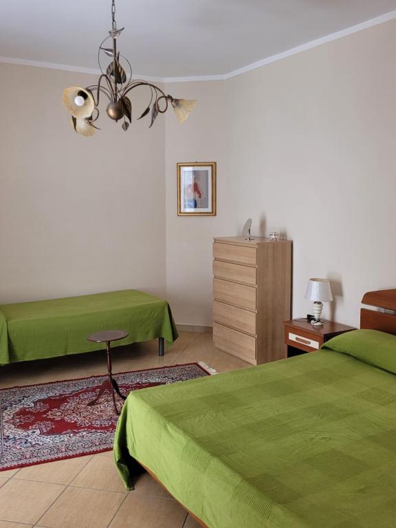 um quarto com 2 camas verdes e uma cómoda em Casa Murales em Diamante