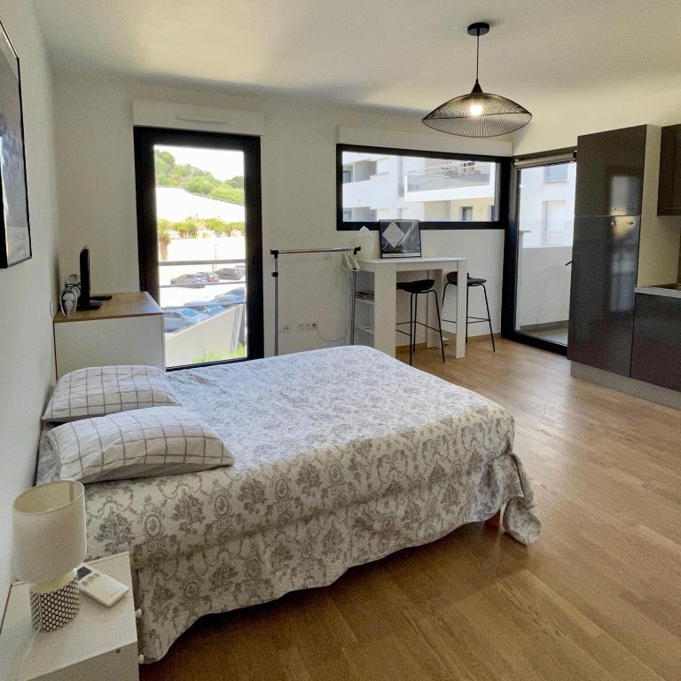 une chambre avec un grand lit et un bureau avec un ordinateur dans l'établissement Parking gratuit grande terrasse Proche Centre Ville, à Ajaccio