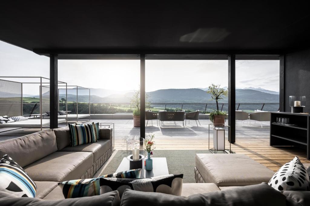 ein Wohnzimmer mit einem Sofa und einem großen Fenster in der Unterkunft Designhotel Gius La Residenza in Kaltern
