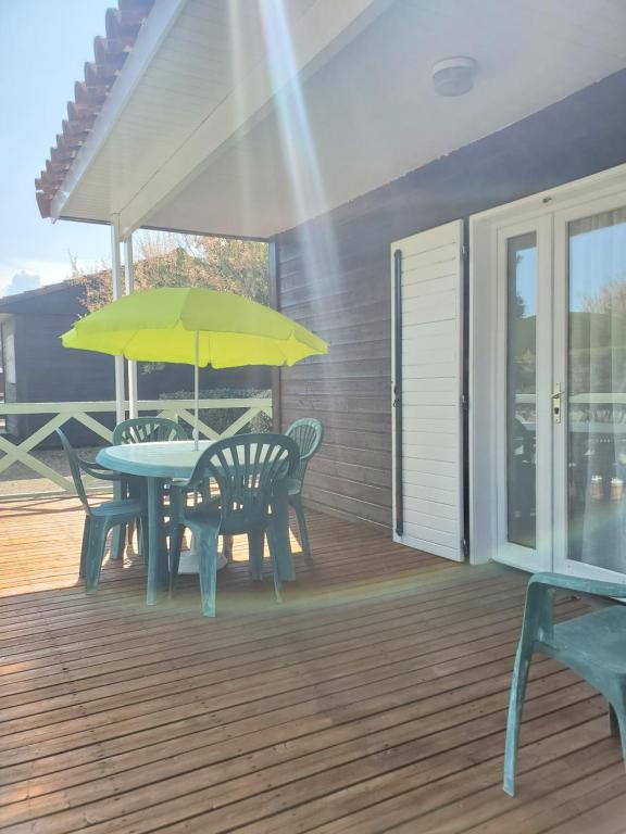 una mesa de patio con una sombrilla amarilla en una terraza en Camping Municipal L'Espazo DURBAN CORBIERES, en Durban-Corbières