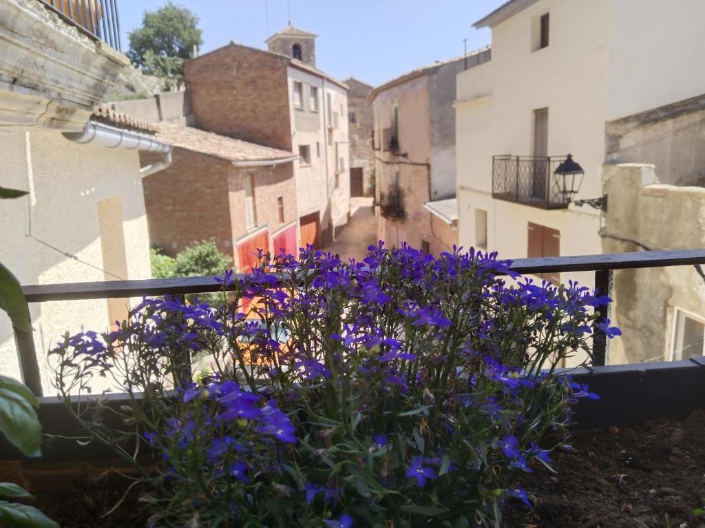 a flower pot on a balcony with purple flowers at CAL BENAIGES in Tartareu