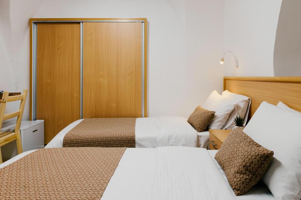 Cette chambre d'hôtel comprend deux lits et un placard. dans l'établissement William's Guest House, à Jérusalem
