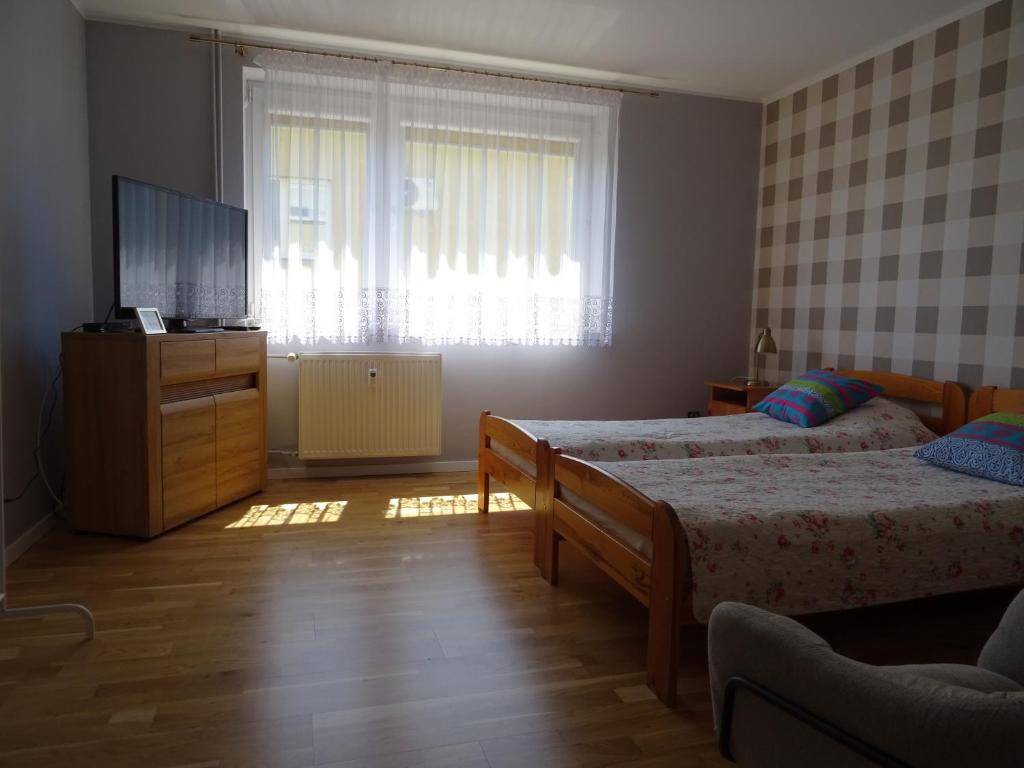 sypialnia z 2 łóżkami i telewizorem z płaskim ekranem w obiekcie Maja Apartamenty we Władysławowie