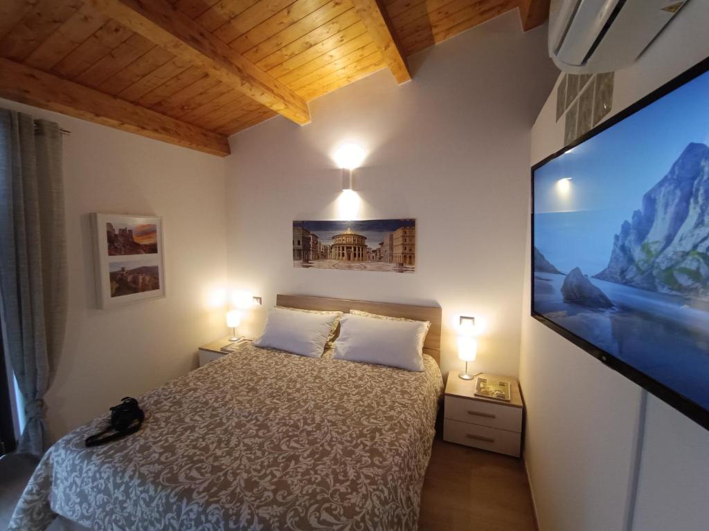 una camera da letto con un letto e una TV a schermo piatto di OH CHE BEL CASTELLO a Ortona