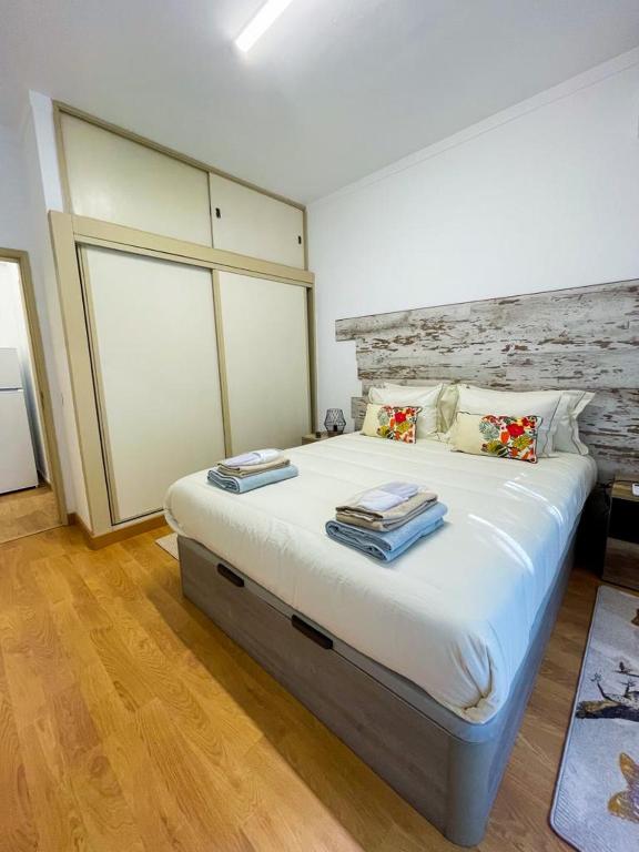 a bedroom with a large bed with two pillows at APART Casas Brancas in Vila Viçosa