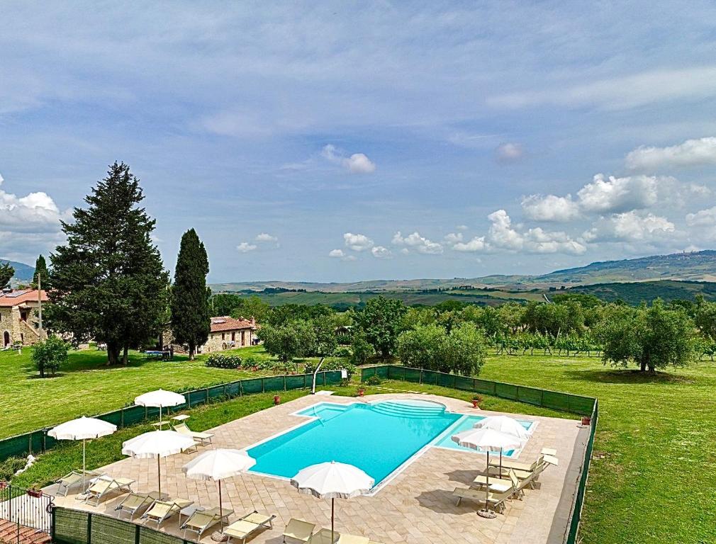 una gran piscina con sombrillas y sillas en Agriturismo L'Antica Quercia, en Pomarance