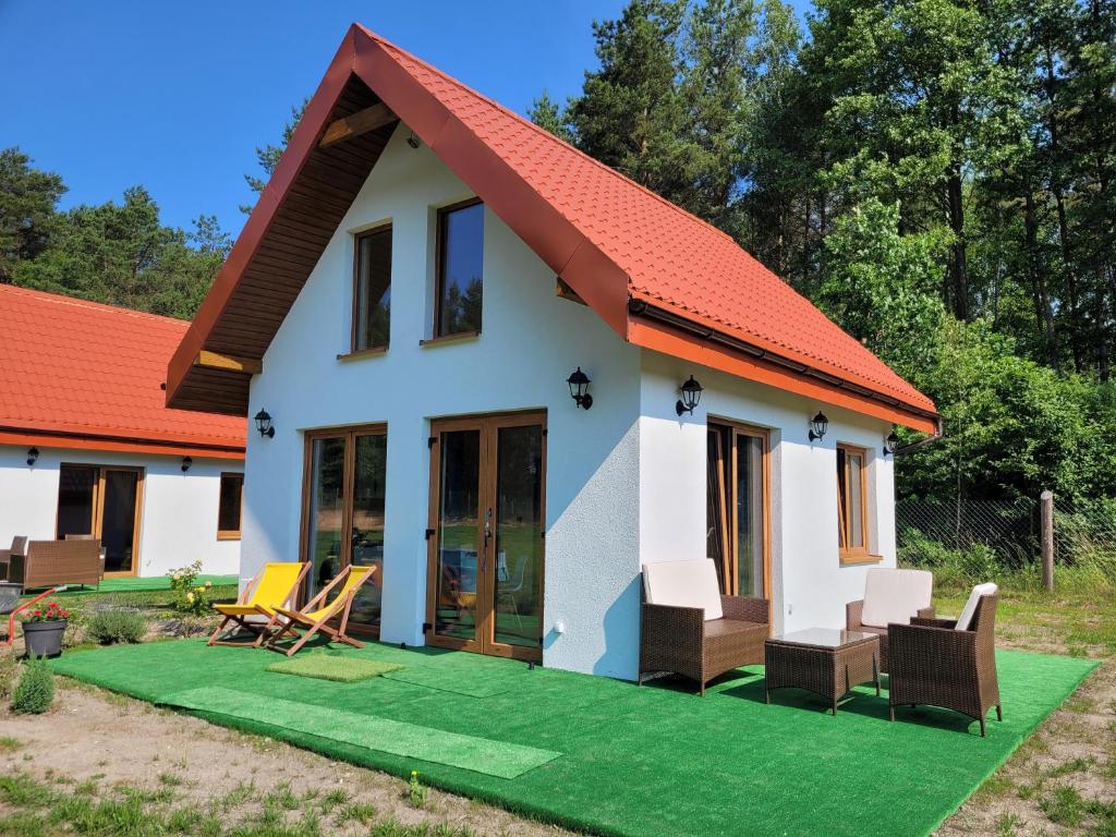 una pequeña casa con techo rojo en Kemping nad stawem, en Harsz