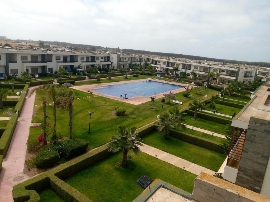 uma vista aérea de um parque com uma piscina em Magnifique villa avec piscine privée dans une résidence sécurisée em Sidi Rahal
