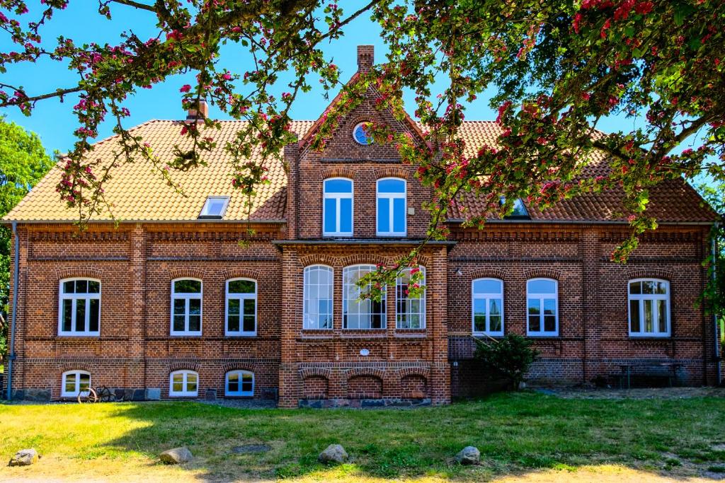 a large brick building with blue windows at Gutshaus Thorstorf FeWo Groß Schwansee in Warnow