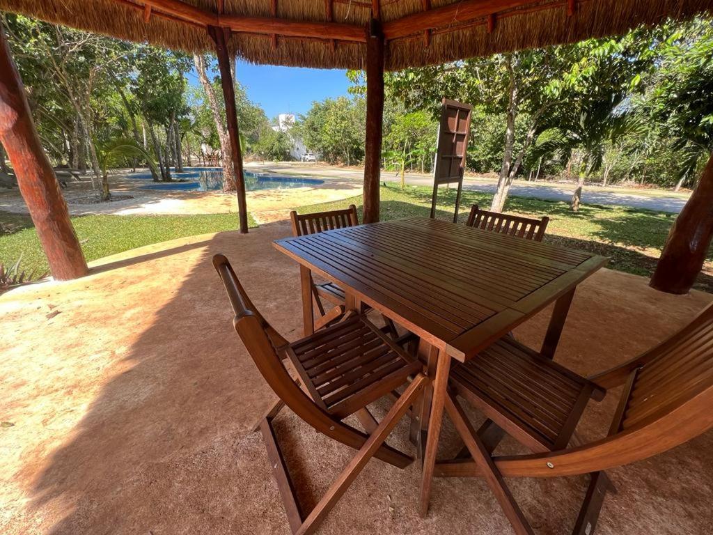 een houten tafel en stoelen onder een prieel bij Tranquilidad y comodidad para ti in Cancun
