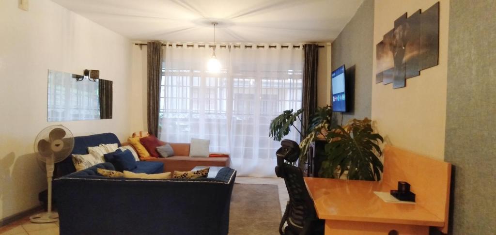 a living room with a couch and a table at Cosy, serene and affordable 2bdr apartment off Waiyaki way in Nairobi