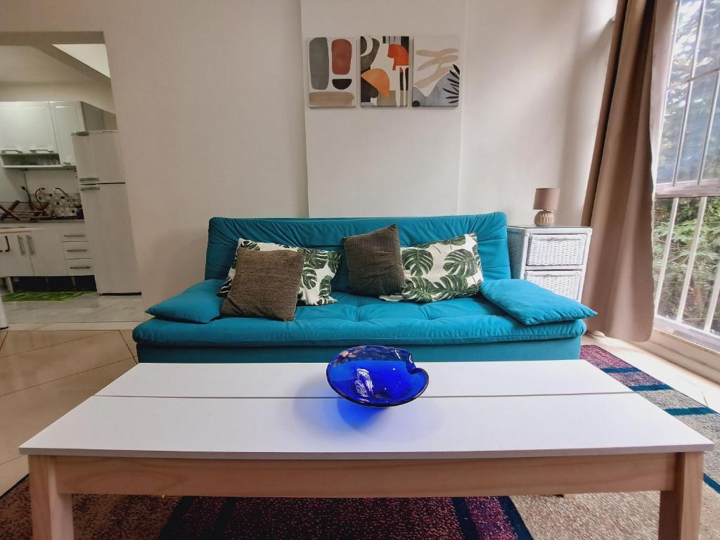 um sofá azul numa sala de estar com uma mesa em Apto com VAGA entre Botafogo e Copacabana no Rio de Janeiro