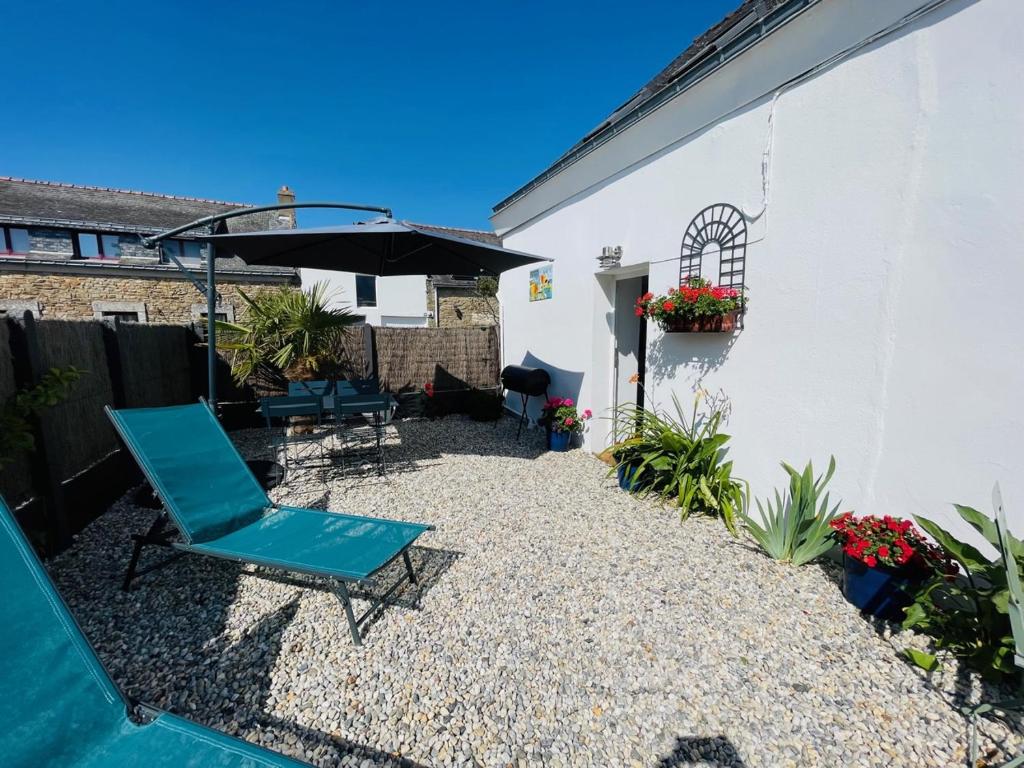 patio con sedia blu e ombrellone di La Petite Maison, charmant Penty coeur de village a Séné